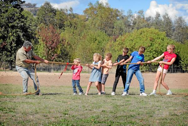 President of the Wymah Family Fun Day committee Mark Lowry takes on Chase Smith-Wood, 4, Elli Lowry, 6, Luke Lowry, 8, Tahj Wood, 10, Khai Wood, 12, and Jessica Lowry, 11, in a tug of war. Picture: TARA GOONAN