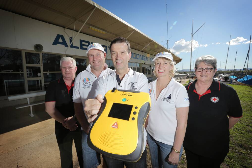 At Albury Wodonga Yacht Club are Red Cross’ Terry Kerr, with Donald Thomson, commodore Jeff Stirling and rear commodore Leanne Thomson, and Red Cross’ Helen Kerr, with the new defibrillator. Picture: TARA GOONAN