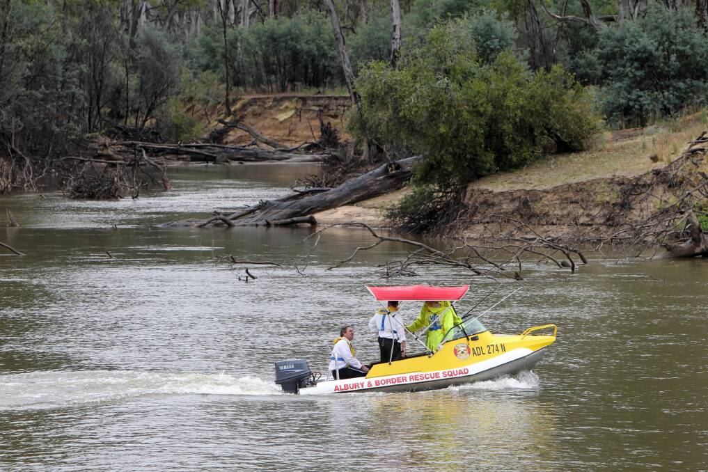 Albury detectives and Volunteer Rescue Association personnel leave the shore at a beach on Bruce’s Bend yesterday to recover the body of a Sydney father who drowned on the weekend. The river lies within NSW. Picture: MARK JESSER