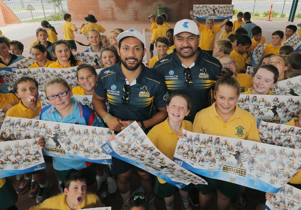 Christian Lealiifano and Fotu Auelua sign posters for youngsters at St Patrick’s Public School yesterday. Picture: TARA GOONAN