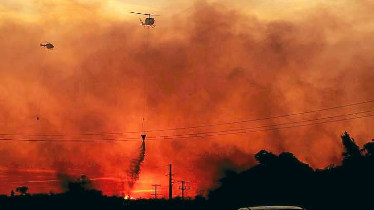 Helicopters drop water on a  fire at Doyalson on the NSW Pacific Highway in late September. Photo: Simone De Peak