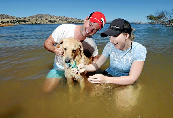 Warwick Knight and Kate Ashworth, from Melbourne, share an ice-cream with their dog Mika to try to keep cool. Picture: KYLIE ESLER