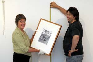 Three new exhibitions in Albury: Rita Lazauskas prepares to hang a work by Aboriginal artist Pooaraar as her Albury Regional Art Gallery colleague Jules Boag looks on. Picture: RAY HUNT