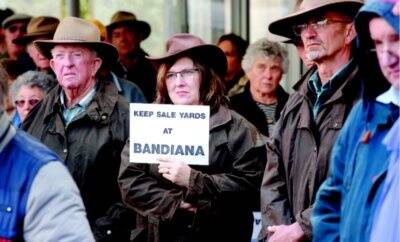 Sonya Salzke, of Jindera, holds a placard during yesterday’s protest rally over the saleyards. Picture: JOHN RUSSELL