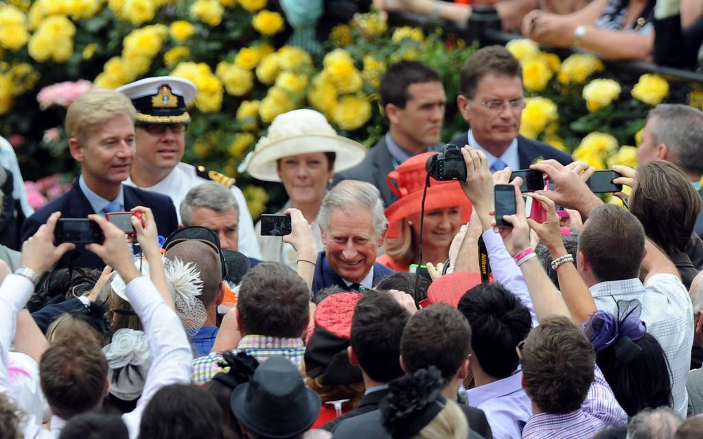 Prince Charles, center, greets the crowd after arriving to watch the running of the Melbourne Cup at Melbourne, Australia.