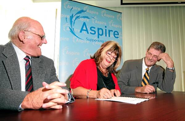 It’s a deal: Vice-president Bruce Gilding, Liz Pogson and president Tony Tinlin sign the merger contracts to form Aspire. Picture: JOHN RUSSELL