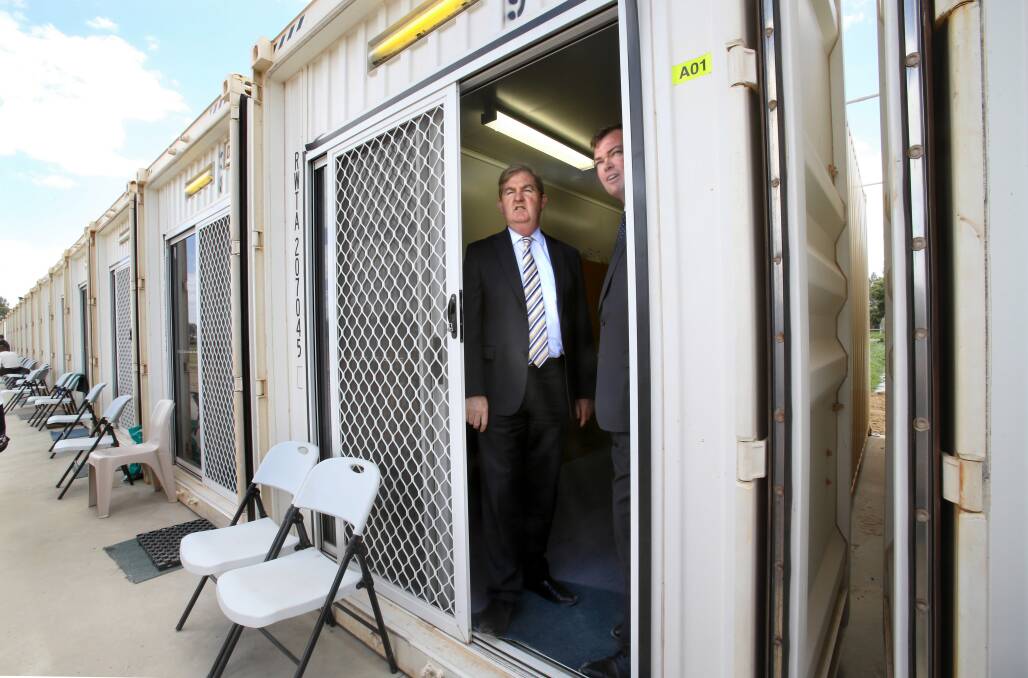 Acting Premier Peter Ryan and Corrections Minister Ed O’Donohue inspect a shipping container cell yesterday. Picture: FAIRFAX