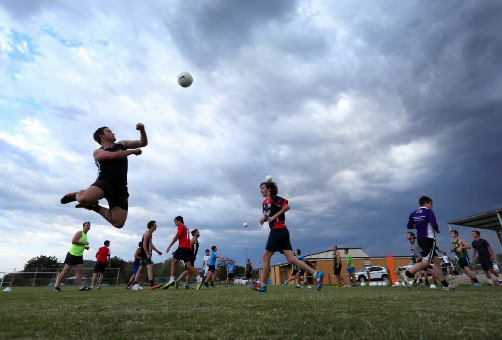 Former Myrtleford midfielder Chris Mitchell shows his athletic ability silhouetted by the storm clouds.