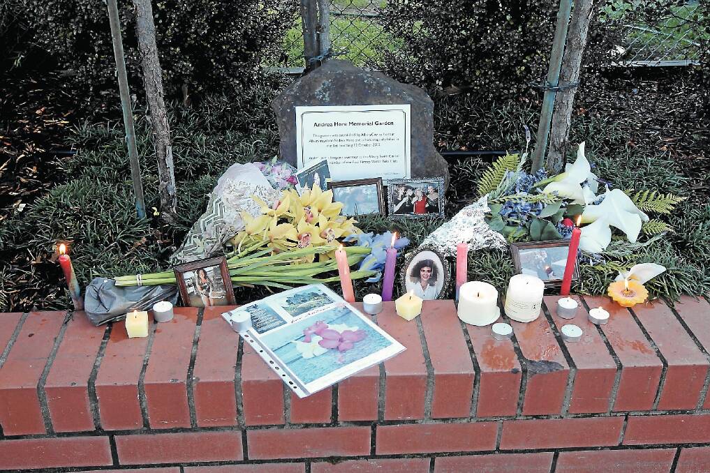 Candles flicker around photos of Ms Hore at the plaque in Albury.