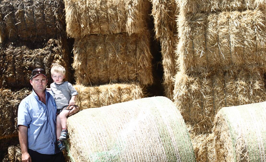 Brendan Farrell, with his son Sam, says he would love to have enough donated hay to help 400 drought-affected farmers feed their stock. Picture: BEN EYLES
