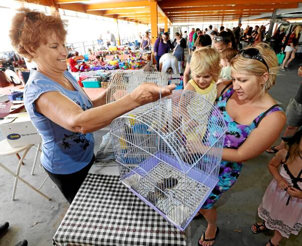 Jennie Williams, of Wodonga, showing a bird and cage to Natalie Nayler and her daughter, Isabella, had a very successful day in the new location for the Sunday market. She says the site has a better atmosphere. Picture: KYLIE ESLER
