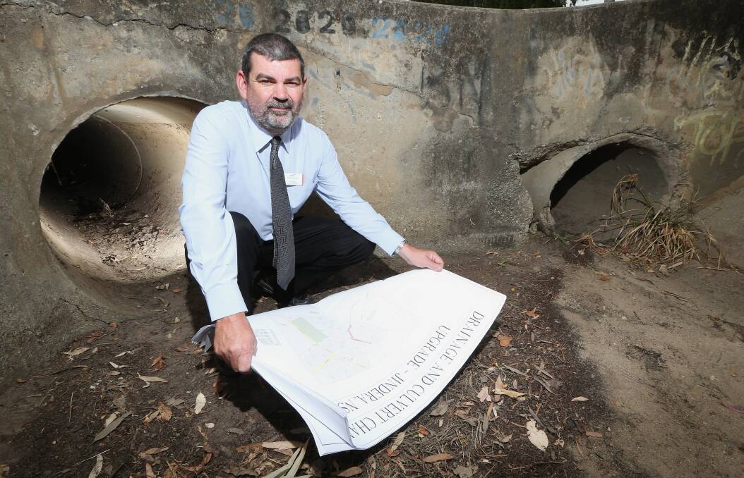 Greater Hume Council engineering director Greg Blackie in the drain at the corner of Adams and Watson streets in Jindera where upgrades will commence on Monday to improve safety. Picture: John Russell