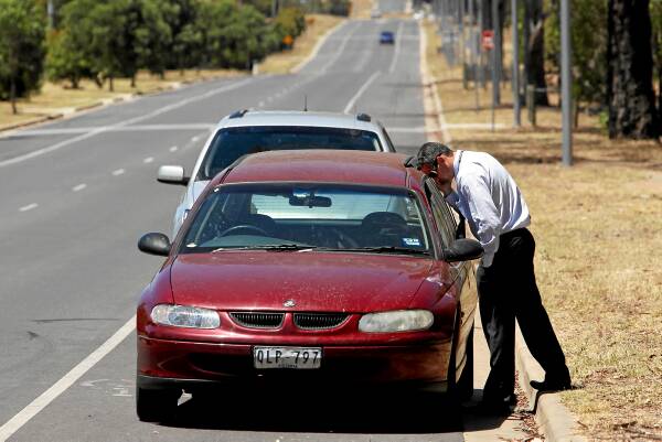 Wodonga’s Detective Sgt Graeme Simpfendorfer examines the getaway car. Picture: Matthew Smithwick