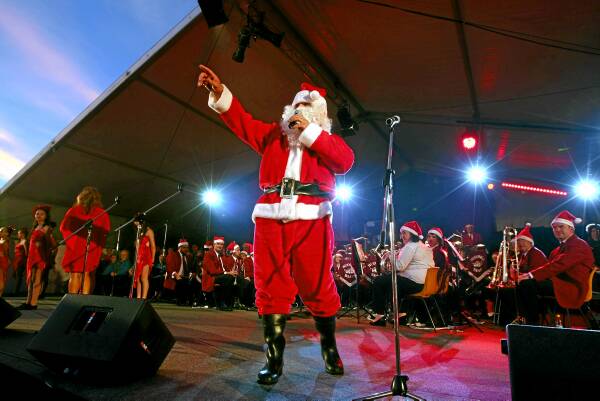 Santa Claus makes an appearance on stage to sing and greet the crowd at last night’s Wodonga Carols by Candlelight. Pictures: MATTHEW SMITHWICK
