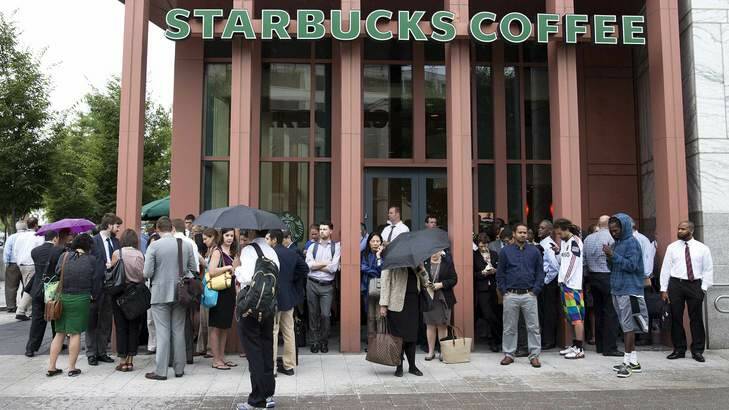 People stand outside a Starbucks Coffee shop that has been closed as police respond to a shooting at the Washington Navy Yard in Washington on Monday. Photo: Reuters / Joshua Roberts