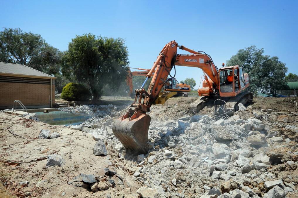 Mark Zollner rips into the task of filling in Thurgoona’s derelict pool yesterday. Picture TARA GOONAN