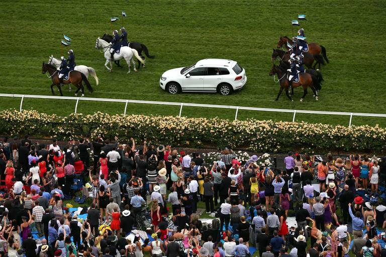 Prince Charles, Prince of Wales and Camilla, Duchess of Cornwall are driven past thousands of racegoers, escorted by Victorian Mounted Police on Melbourne Cup Day at Flemington Racecourse in Melbourne, Australia.