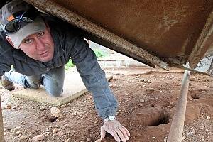 Yerong Creek's Greg Male with some mouse holes under the grain storage tanks. PICTURE: Peter Merkesteyn.