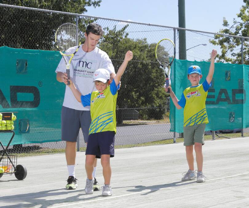 St Patrick’s Tennis Club coach Mark Shanahan corrects the technique of Rory Parnell, 8, of Albury, and Ryan Johnston, 8, of Albury. The junior tennis Hot Shots program is aiming to get more youngsters picking up a racquet. Picture: TARA GOONAN