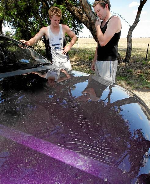 Nick and Justin Brockley show the marks left by power lines falling on the bonnet of the utility.