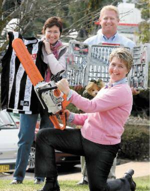 Trish Ryan, Daron White and Libby Keogh with some auction items. Picture: PETER MERKESTEYN