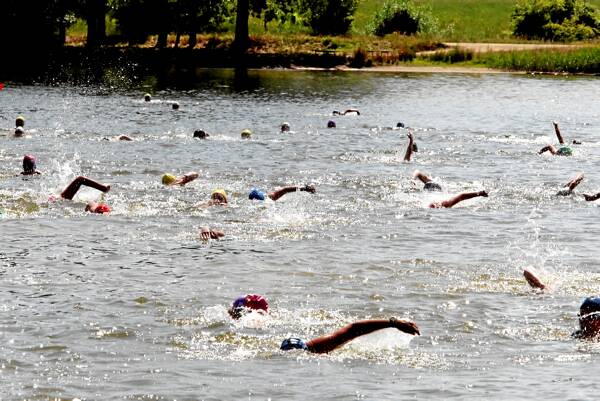 Competitors swim across the dredge hole in the first leg of the triathlon.