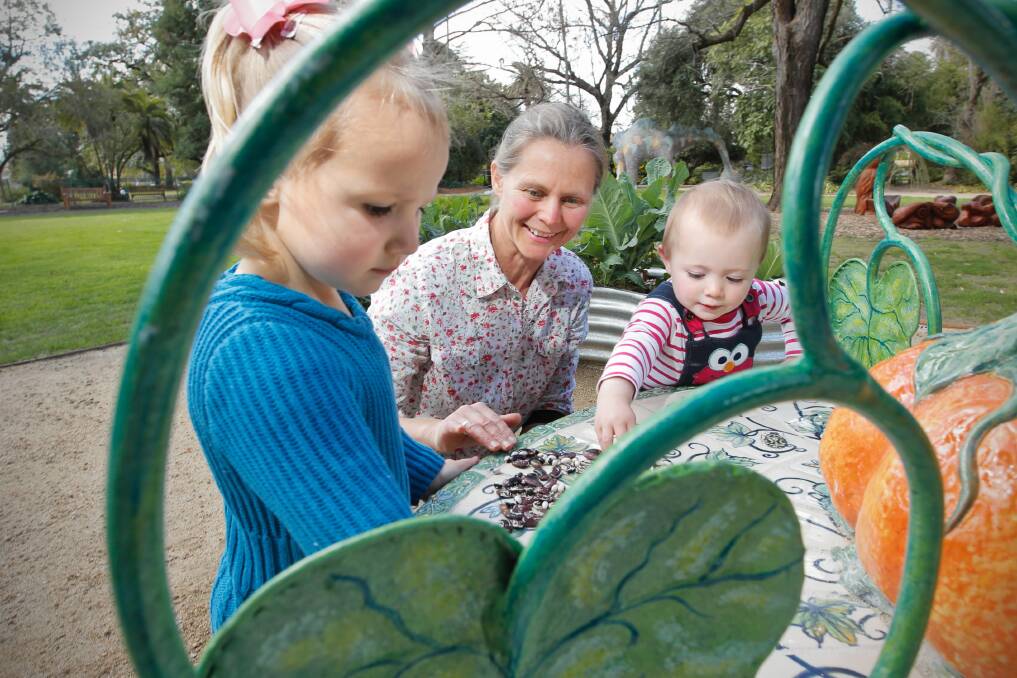 For the Poulton girls Jasmine, 3, and Sophie, 18 months, it’s never too soon to start learning as botanic gardens’ volunteer Lou Bull introduces them to various seeds yesterday. Picture: BEN EYLES