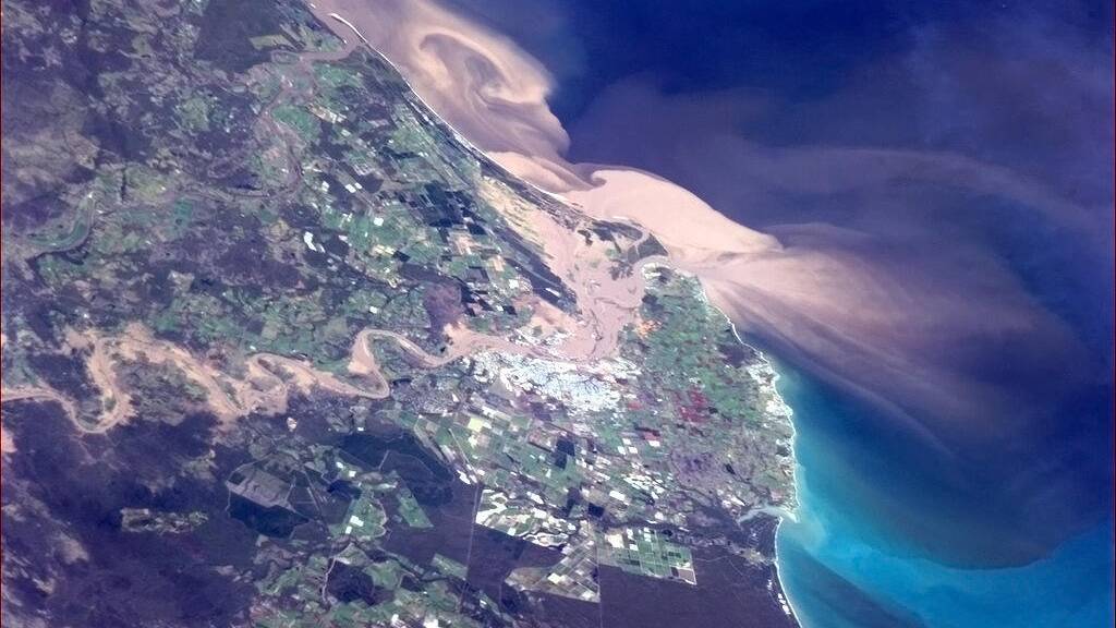 Floodwater flow from Bundaberg into the ocean. Photo: Commander Chris Hadfield
