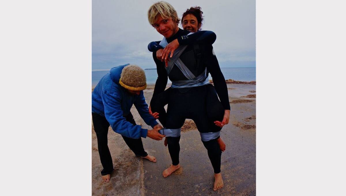 Pascale Honore gets affixed to her surfing friend Ty Swan with duct tape.