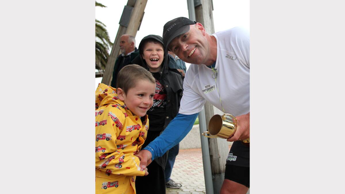 EPIC RUN: Charity runner Tim Blair greets Ulverstone boy Trystan Stephens after running from Devonport to Burnie and back with mate Shane Taylor yesterday. Picture: Stuart Wilson.