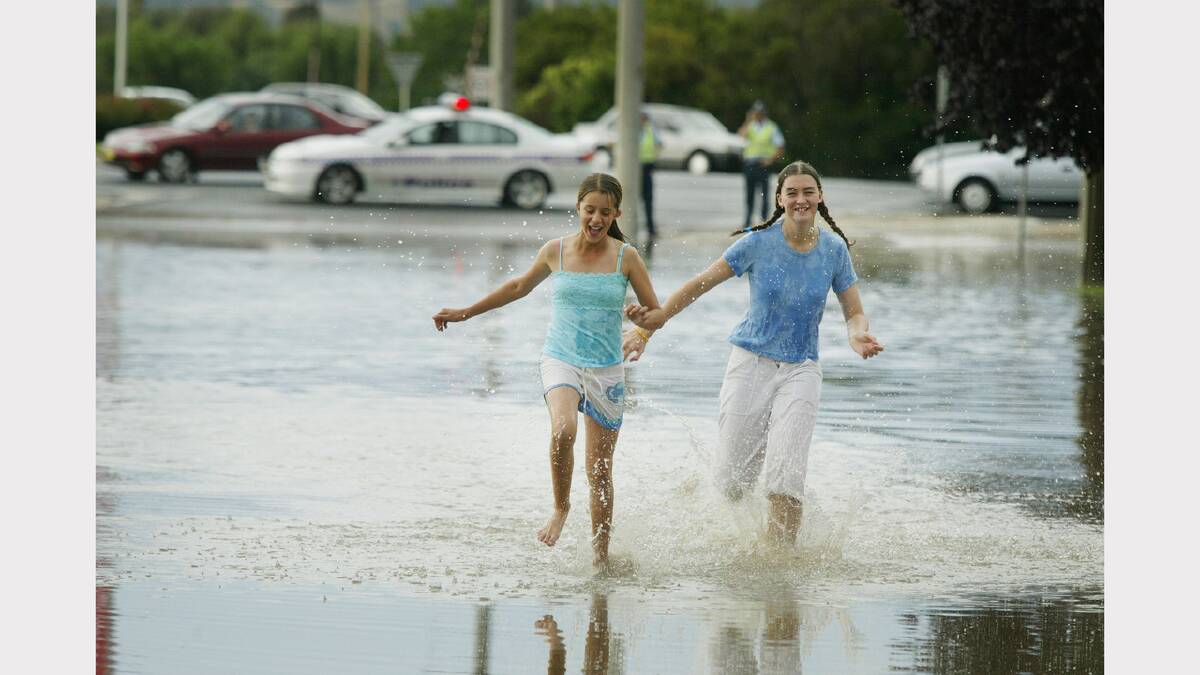 Wodonga was hit by a storm that caused flash flooding. Catherine Odgers 13 & Jennifer Robinson 13 of Wodonga running throgh water in Melrose Drive. Picture: SIMON DALLINGER