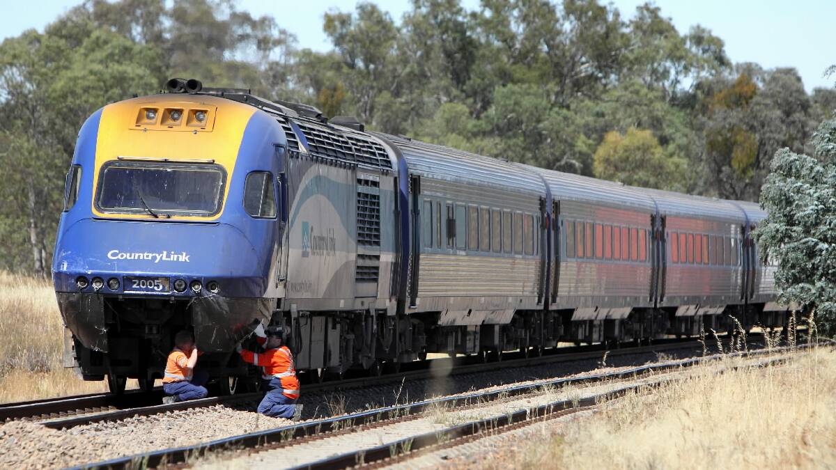 CountryLink workers inspect the damage to the XPT after the crash.