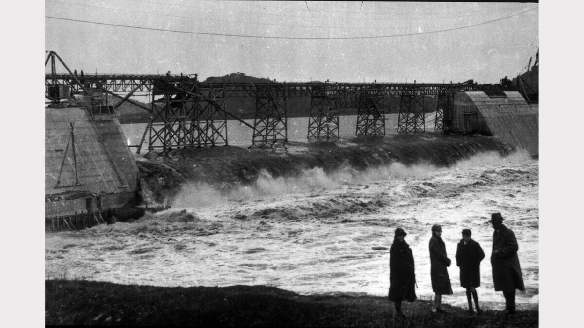 Floodwaters sweep through construction works at Hume Dam, about 1930.