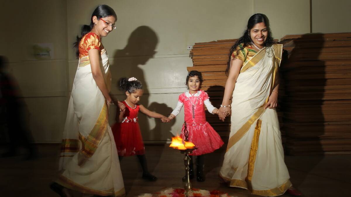Nia Manoj, 4, Jismi Deepu, Sreeja Satyan and Gloria Thomas, 5, dance around the Pookalam to celebrate the return of the Indian king Mahabali. Picture: MARK JESSER