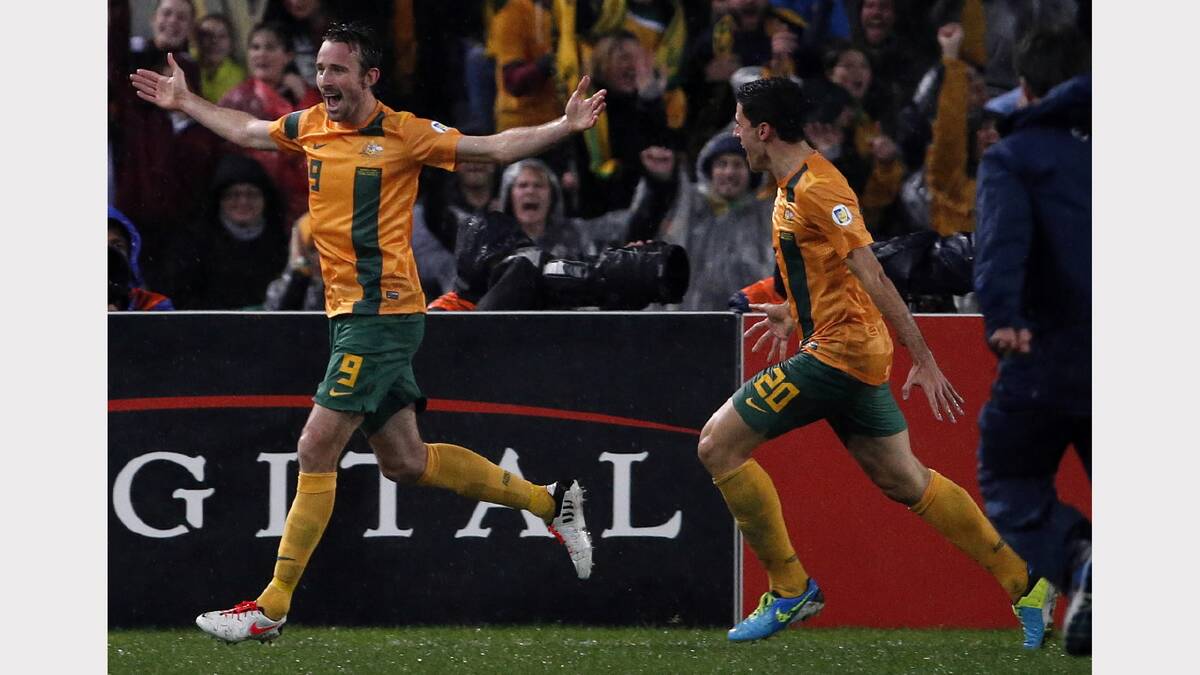 Josh Kennedy celebrates with teammate Tom Rogic after scoring the game-winning goal during the World Cup qualifying game against Iraq at Stadium Australia on June 18. Picture: REUTERS
