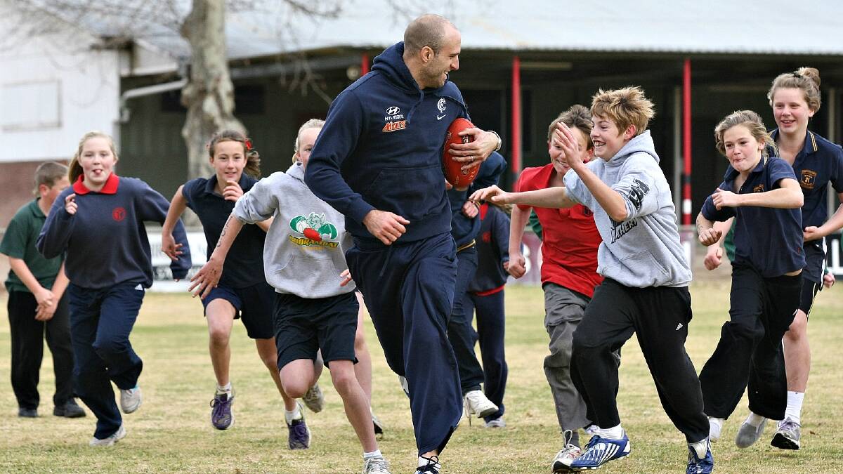 Carlton in the North East. Chris Judd leads the school students on a merry dance.PICTURE: John Russell.