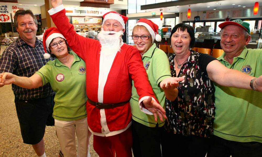 Thurgoona Lions Club members Ian Crane, Lyn Taylor, Chris Rane, dressed as Santa Claus, Viv Rane, Liz Crane, and Des Lum want a Carols by Candlelight to be up and running in the ever-growing community by next year. Picture: MATTHEW SMITHWICK