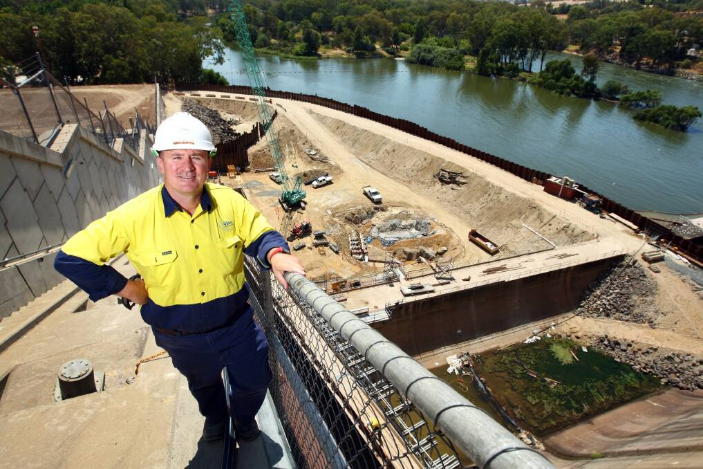 Mark Pearson stands on the buttress wall, the coffer dam, on right, holds back the river. Pictures: MATTHEW SMITHWICK.