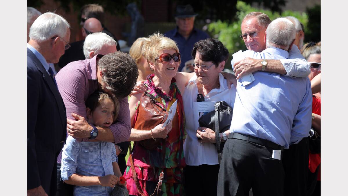 Wally Moras’ grandson Brett Kirk hugs his son while Mr Moras’ daughter Sue Kirk is consoled after the funeral of the World War II veteran at St Matthew’s Church in Albury yesterday. About 500 attended the funeral. Pictures: TARA GOONAN