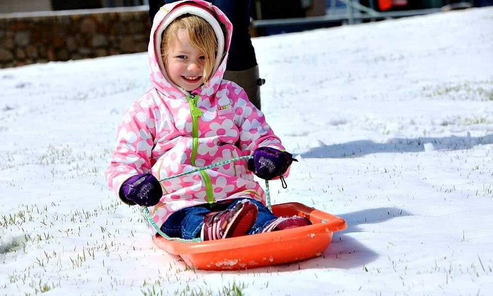 Fall Creek local Romy Jackson, 3, delights in the snowy surprise at Falls Creek today as a cold blast delivered sub-zero temperatures and a blanket of white. PICTURE: Chris Hocking.