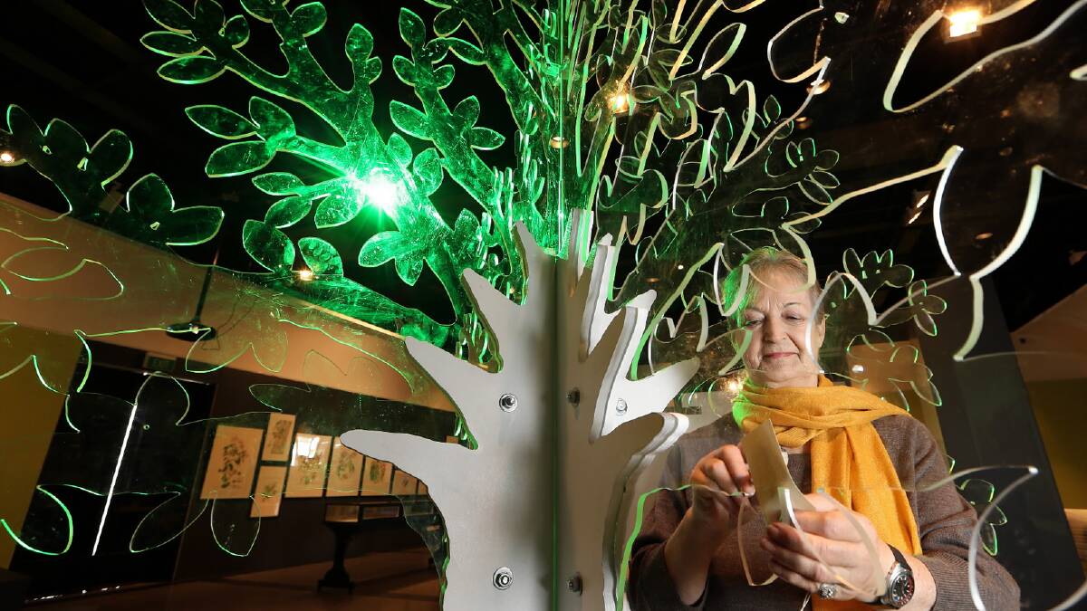  Corowa artist Moira Russell adds a note to the memory tree at the Albury Botanic Gardens exhibition. Picture: Kylie Esler