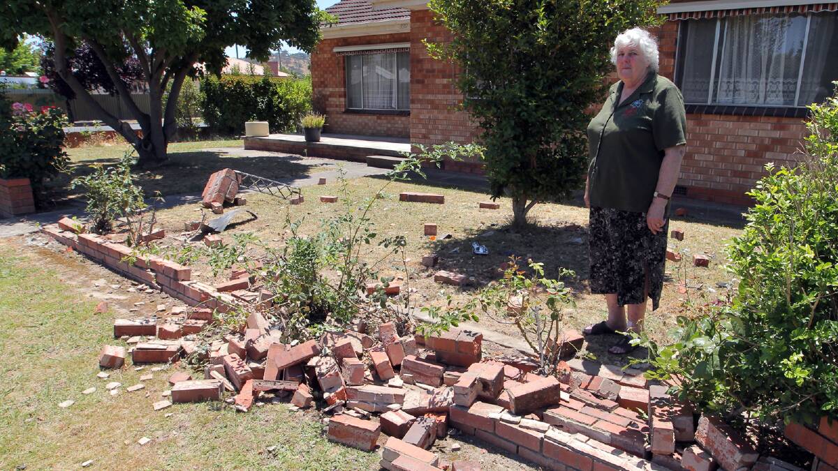 Doreen Drumgold with the remains of her front fence after a car was driven into it. Picture: DAVID THORPE