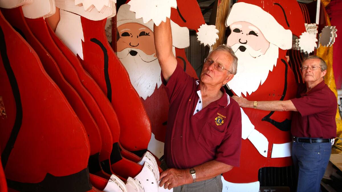 Wodonga Lions Club’s Ray Locke and Harold Cover with some of the Santa cutouts that will be sold at a clearing sale next month after adorning the streetscape for decades. Picture: MATTHEW SMITHWICK 