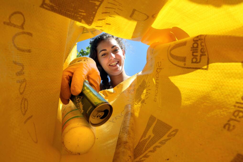  Laura Dingle, 16 of Thurgoona places some rubbish into a bag at Bonnie Doon Park. Picture: PETER MERKESTEYN