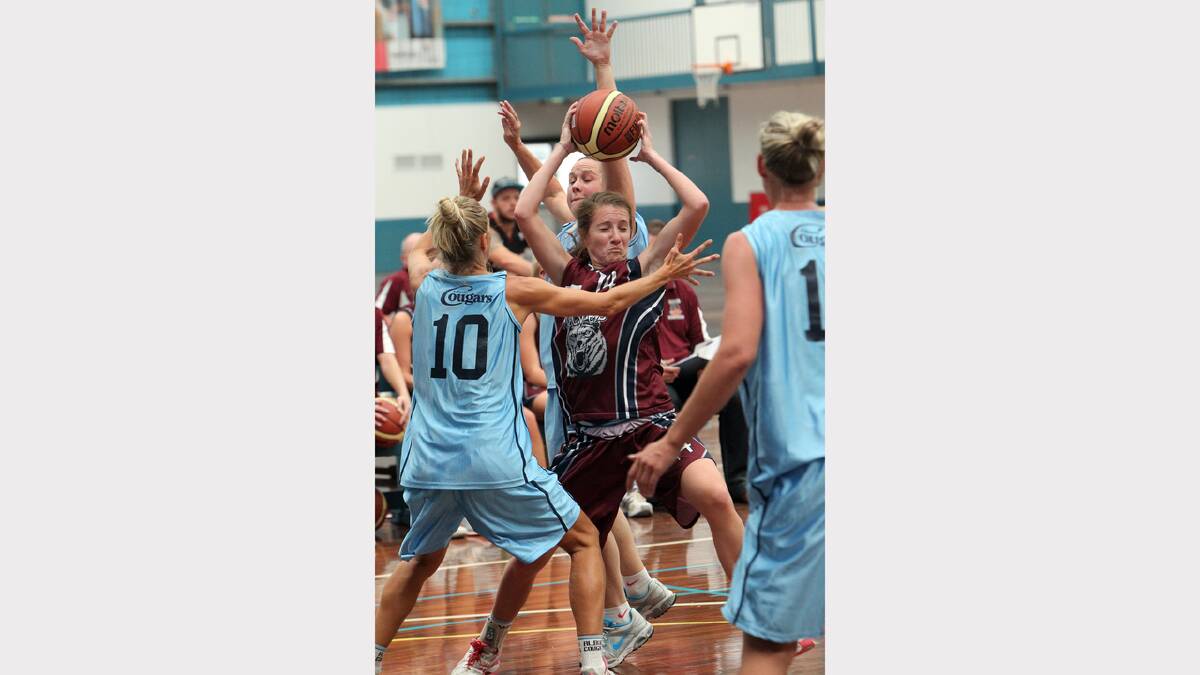 Wodonga Wolves' Tahnee Cannan (centre) tries to work her way out of a the cougars rough defence. 