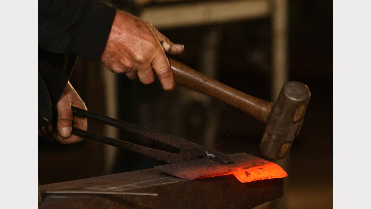 14. Blacksmith Max Bowran pounds a bend into a piece of metal. Picture: BEN EYLES