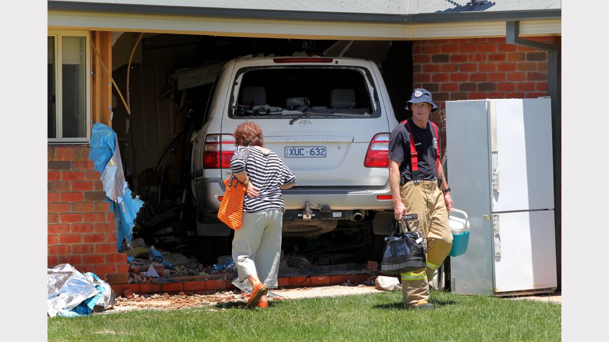 Fire, SES and RACV crews work to remove the car from the house. Pictures: DAVID THORPE