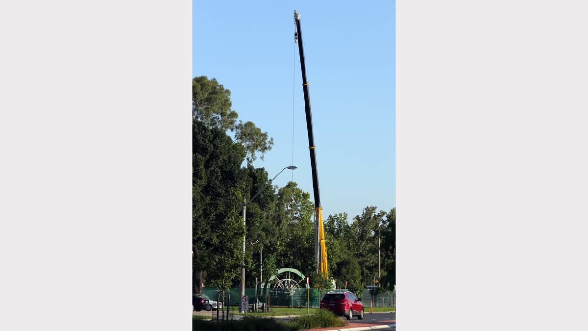 A crane has begun removal works of Albury's historic water wheel. Pictures: PETER MERKESTEYN