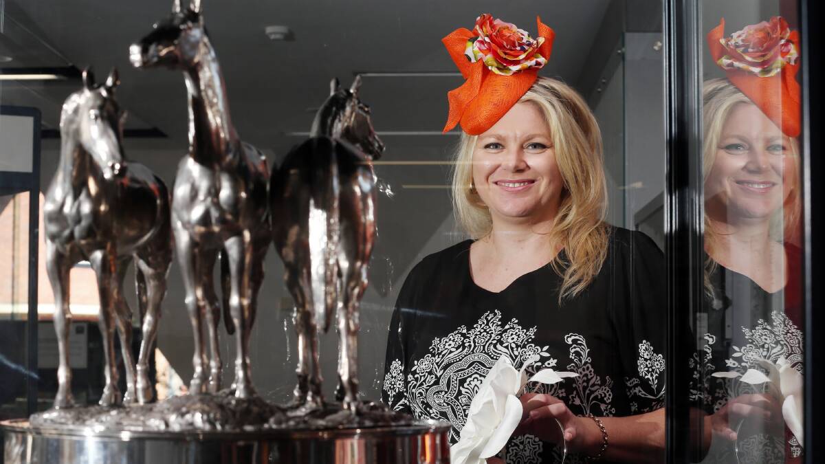 Qualified milliner Rachael Hart with the 1888 Melbourne Cup wearing the silk flower fascinator she’ll show people how to make in her workshop. Picture: JOHN RUSSELL