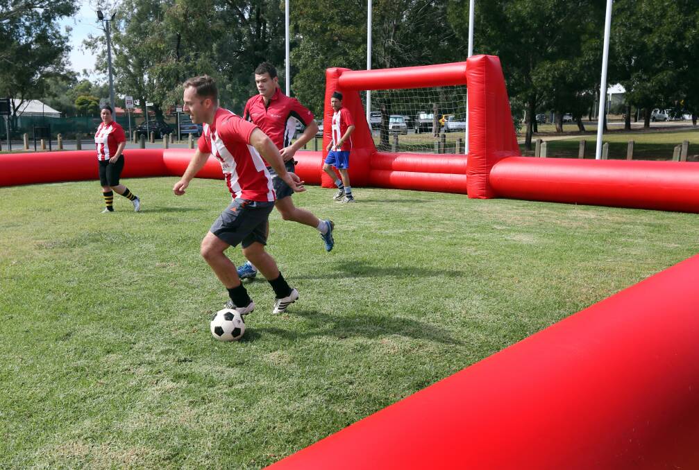 Players use an inflatable soccer pitch during a practice match at L a Trobe University. 